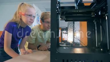 兴奋的学生使用三维<strong>打印机</strong>创建三维<strong>打印机</strong>器人。